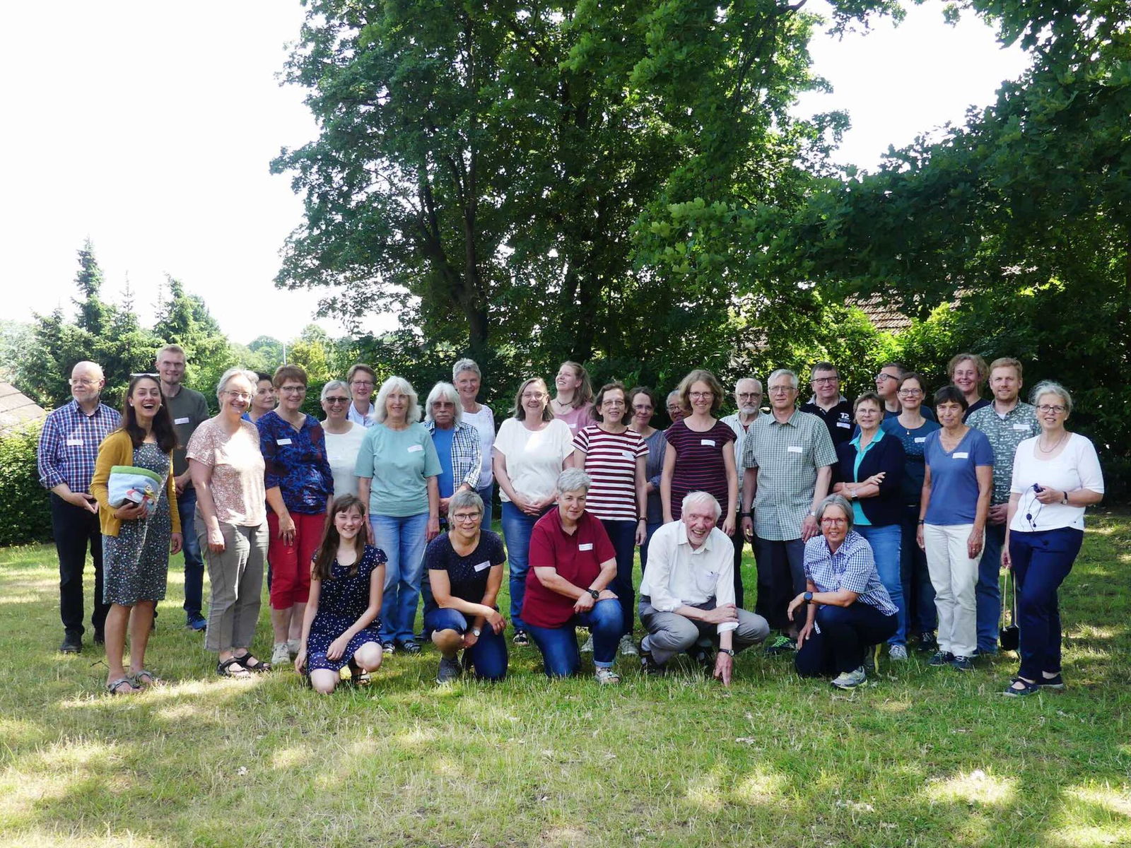 Eine Gruppe von Menschen steht in einem Park. Sie tragen Sommerkleidung. Das Foto zeigt die Schoepfungsbotschafterinnen.