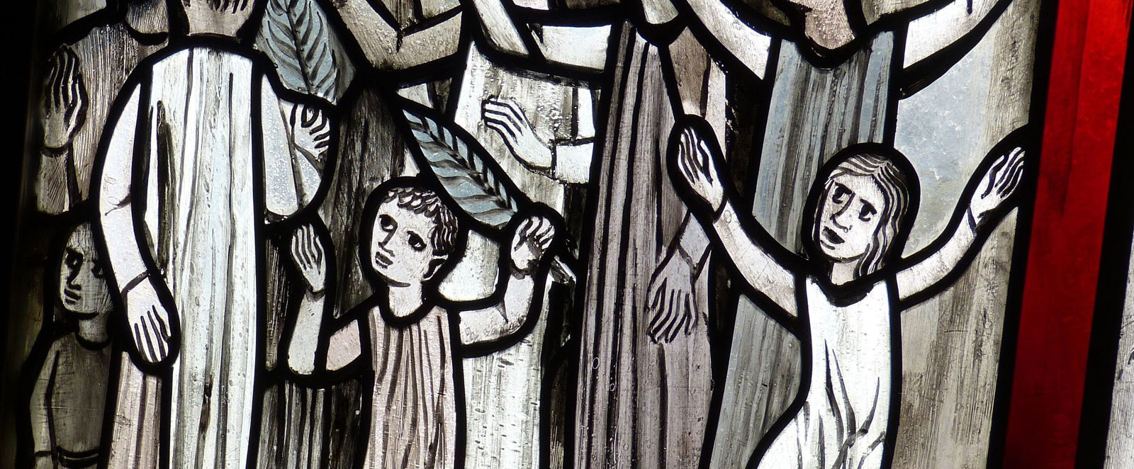 Ein Fensterbild, auf dem Menschen mit Palmzweigen wedeln und jubeln.