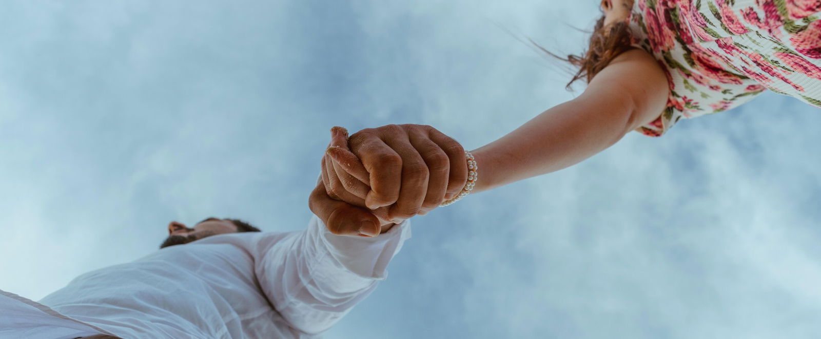 Ein Mann und eine Frau halten sich an der Hand.