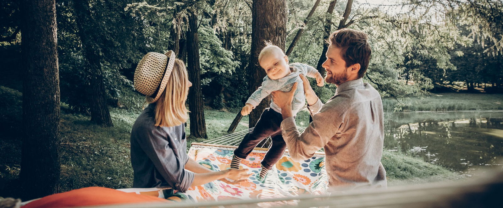 Eltern mit ihrem Kind in einem Park an einem See. 