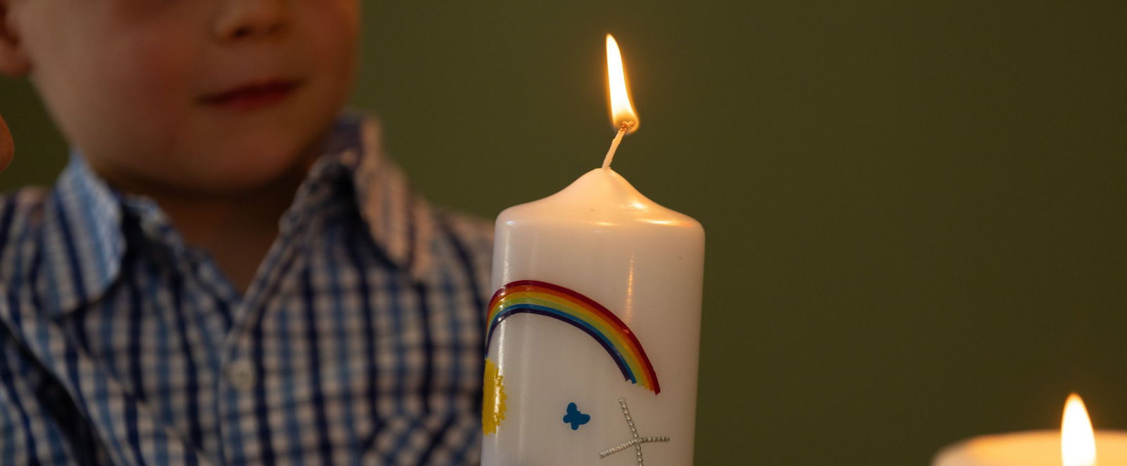 Ein Kind mit einer Kerze.