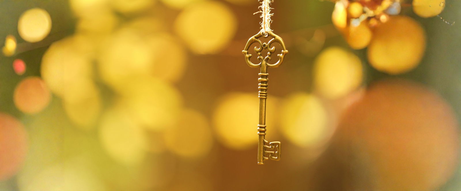 Ein goldener Schlüssel vor goldenem Hintergrund.