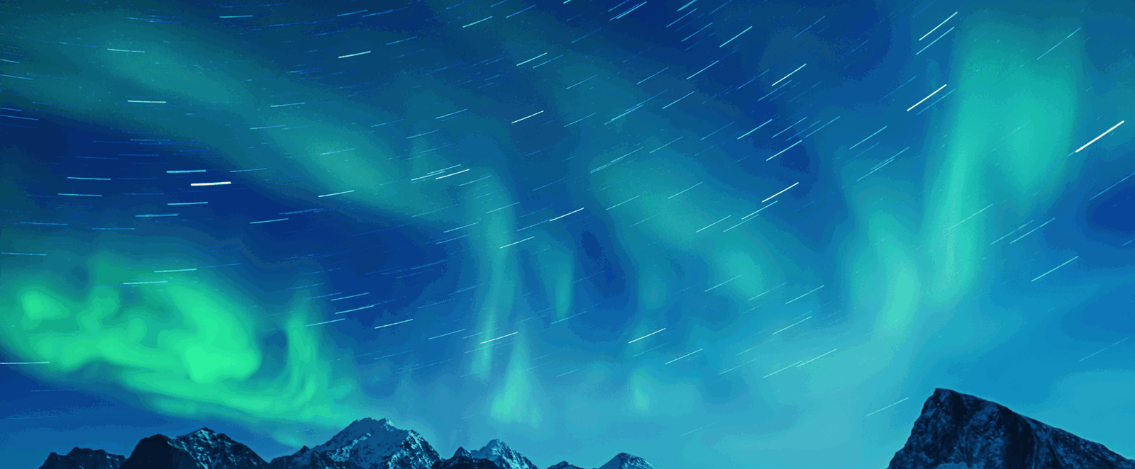 Über Bergen flackern in unterschiedlichen Grüntönen Polarlichter.