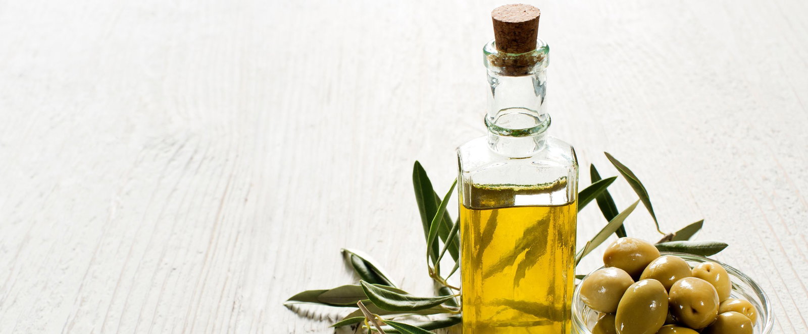 Eine Karaffe Öl und Oliven.