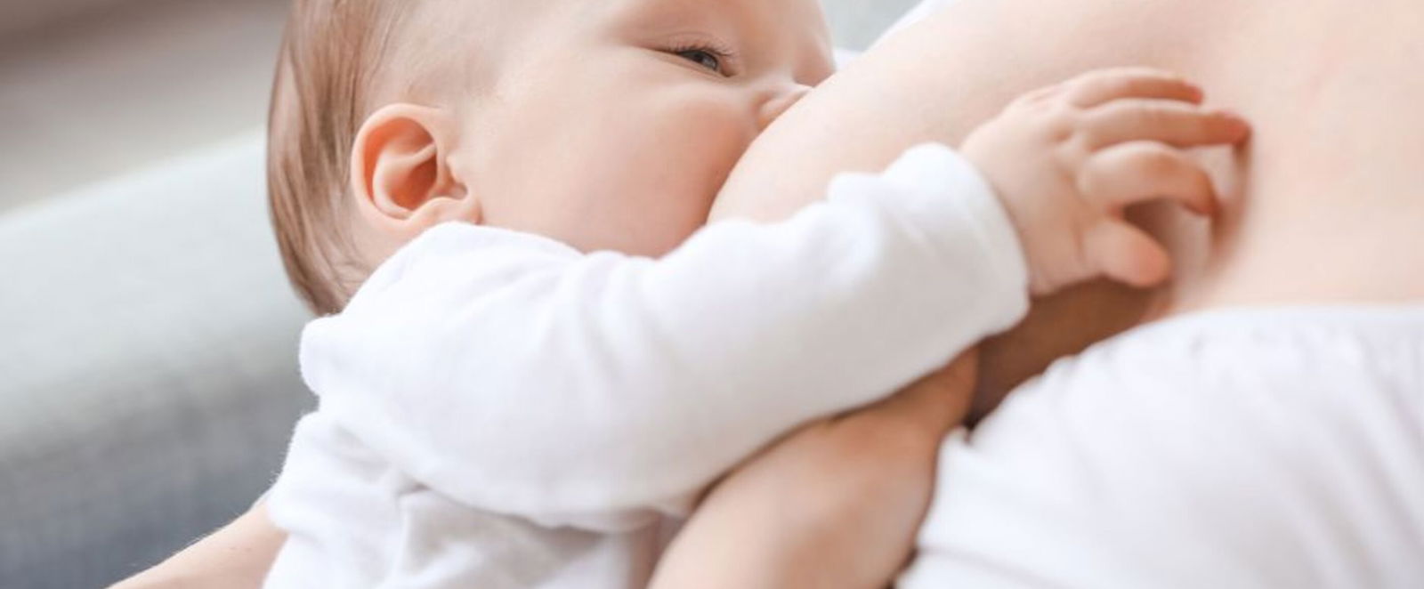 Ein Baby trinkt an einer Brust.