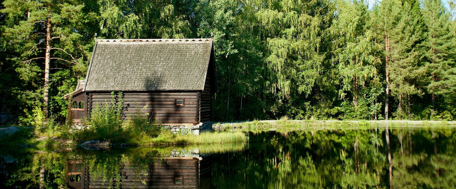 Eine kleine Hütte am Waldrand an einem See