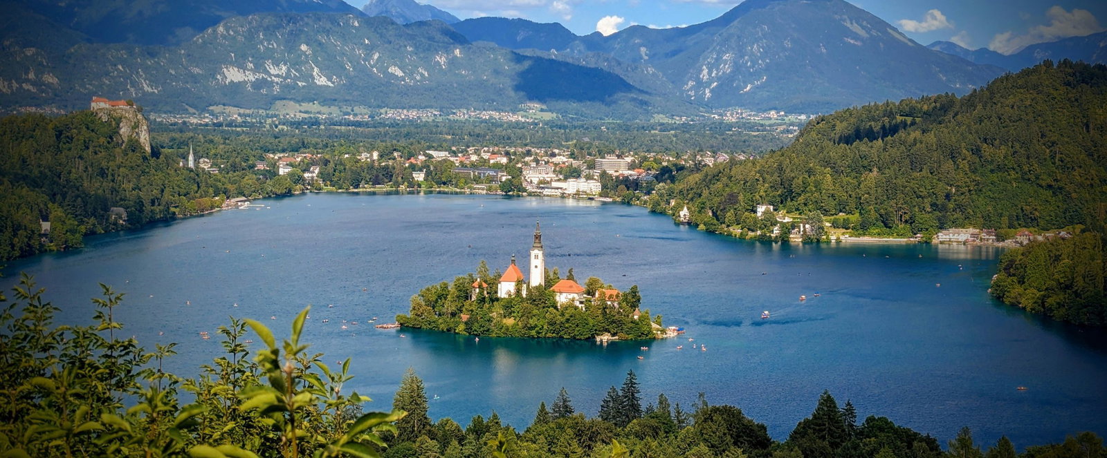 Auf einer kleinen Insel in einem Fluss stehen mehrere Häuser und ein Kirchturm.