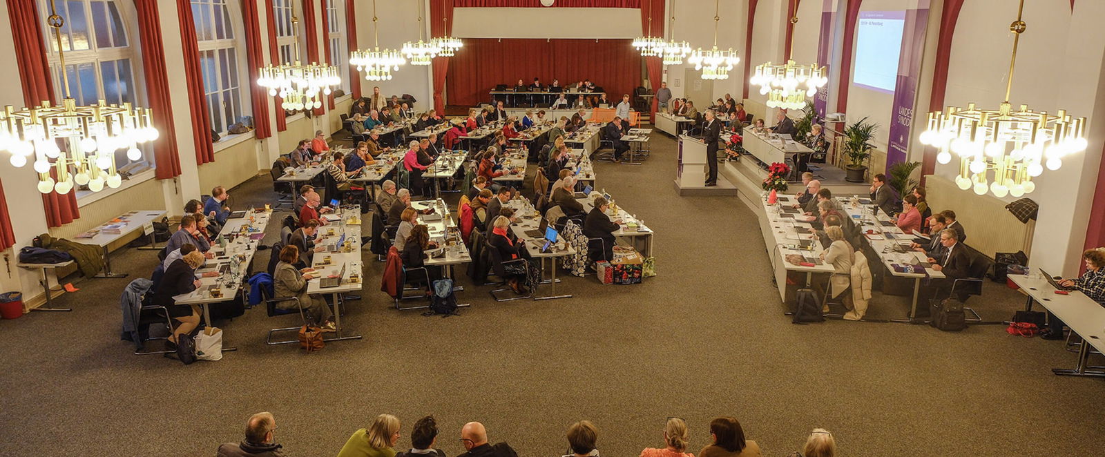 Mehrere Personen in einem Sitzungssaal