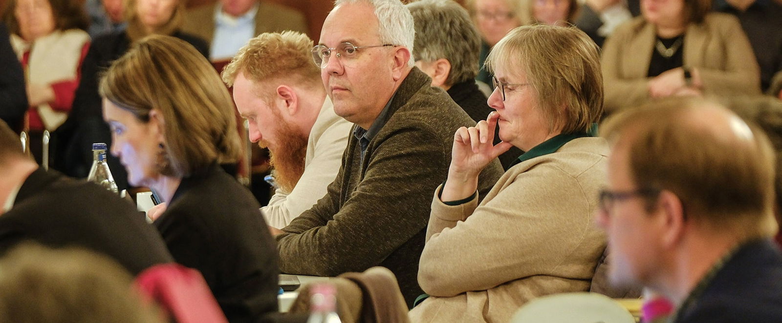 Mehrere Personen in einem Sitzungssaal