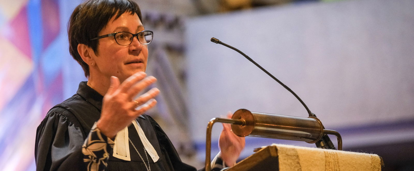 Die Regionalbischöfin steht an einem Pult und predigt.