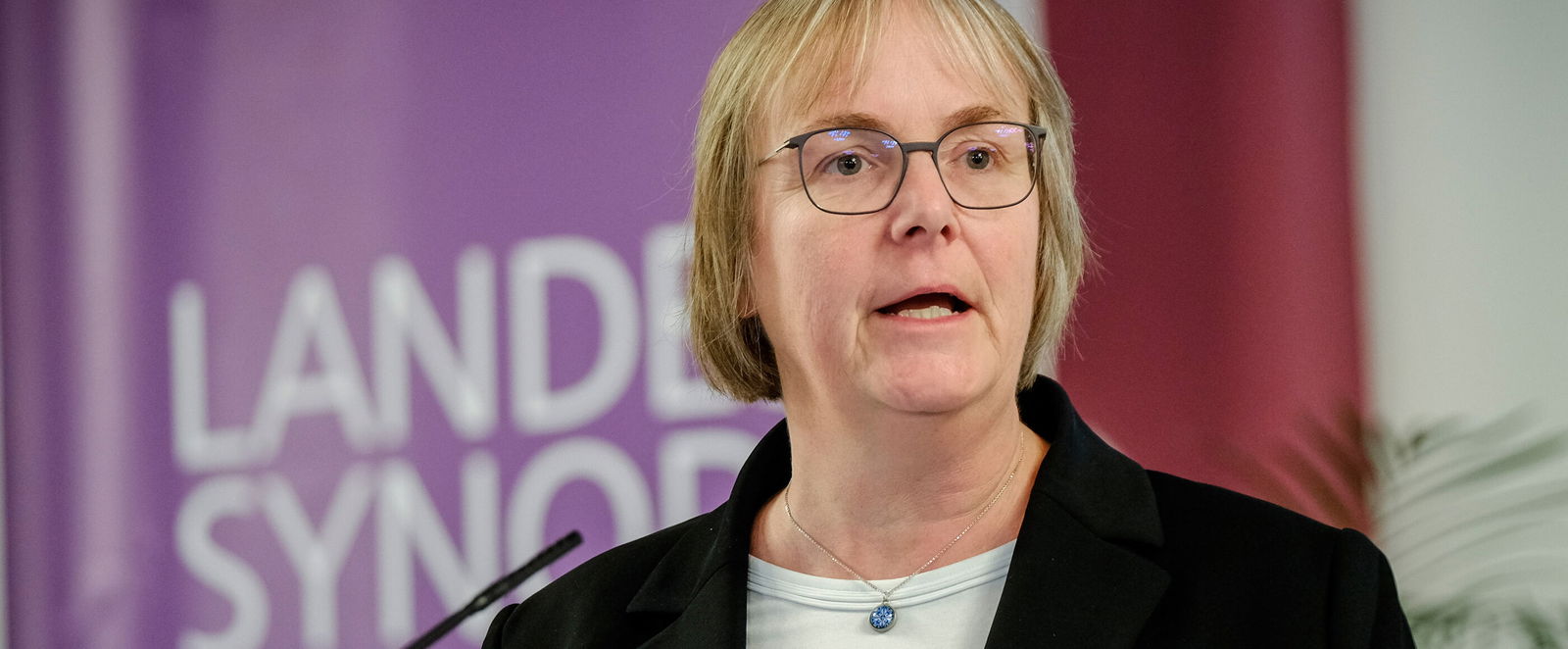 Eine weiblich lesbare Person an einem Rednerpult