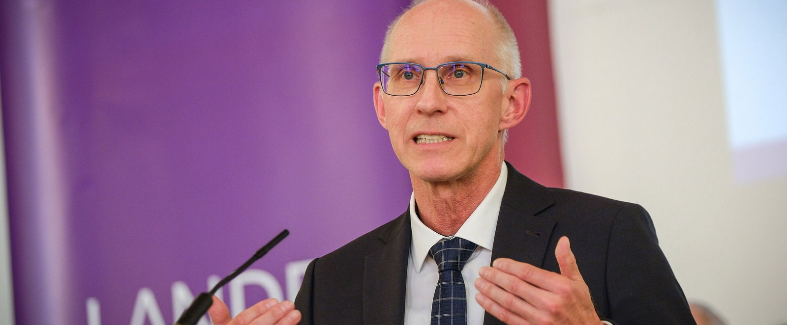 Eine männlich lesbare Person am Rednerpult