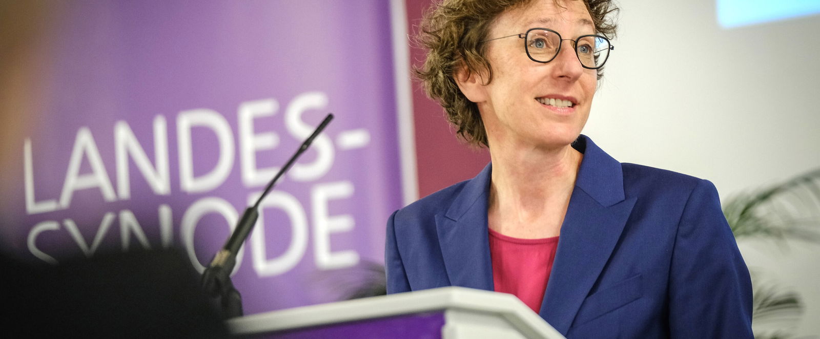 Eine weiblich lesbare Person an einem Rednerpult