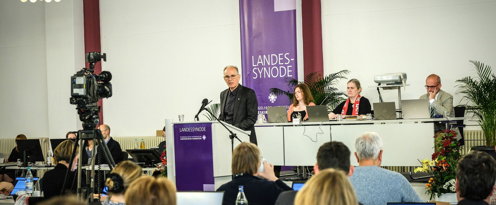 Mehrere Personen in einem Sitzungssaal