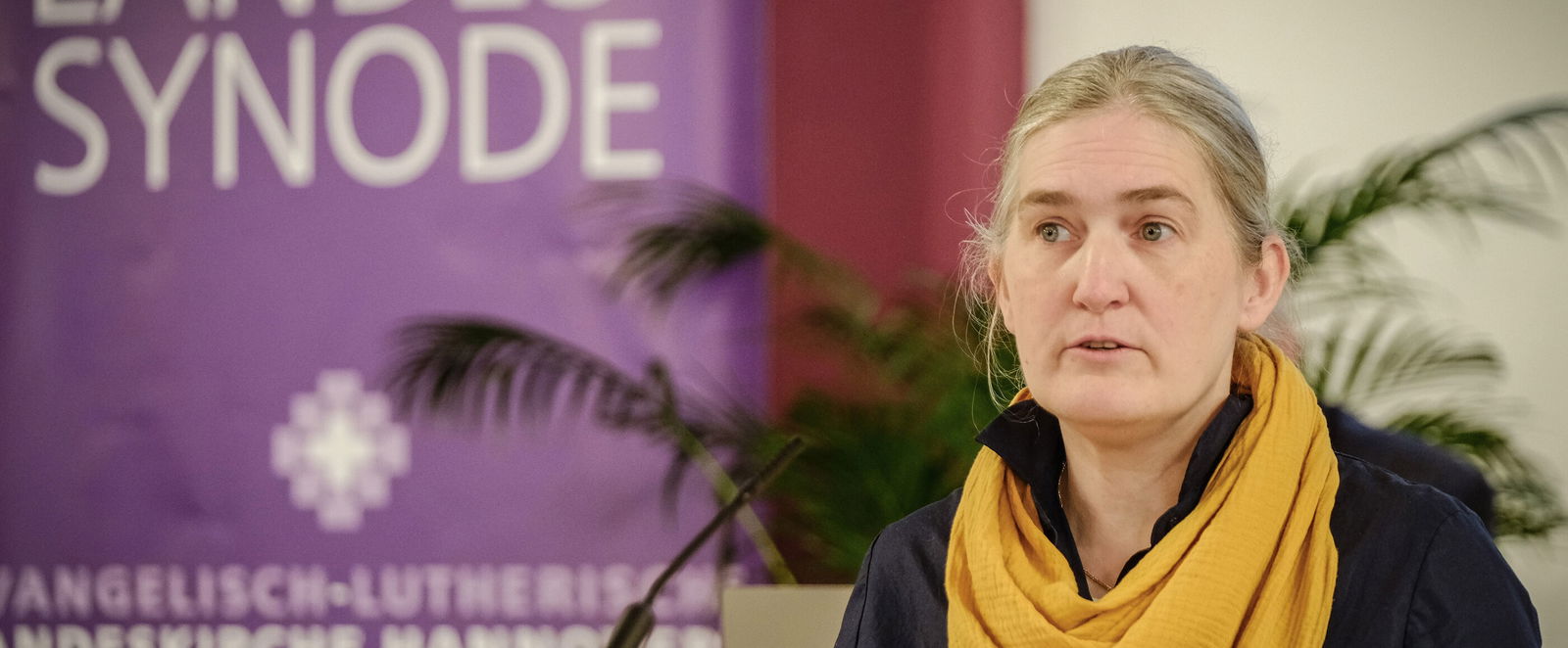 Eine weiblich lesbare Person an einem Rednerpult