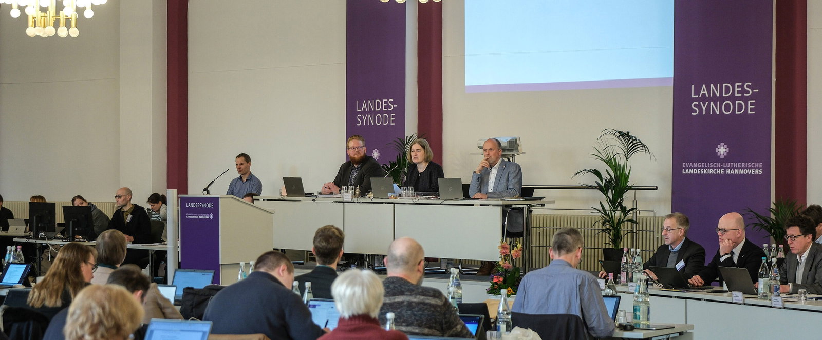 Mehrere Personen in einem Sitzungssaal