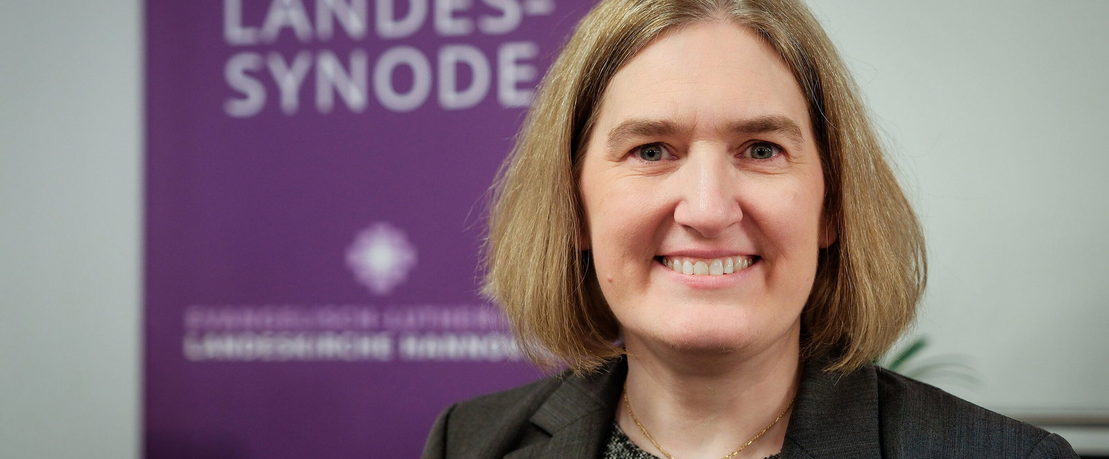 Eine weiblich zu lesende Person lächelt in die Kamera.