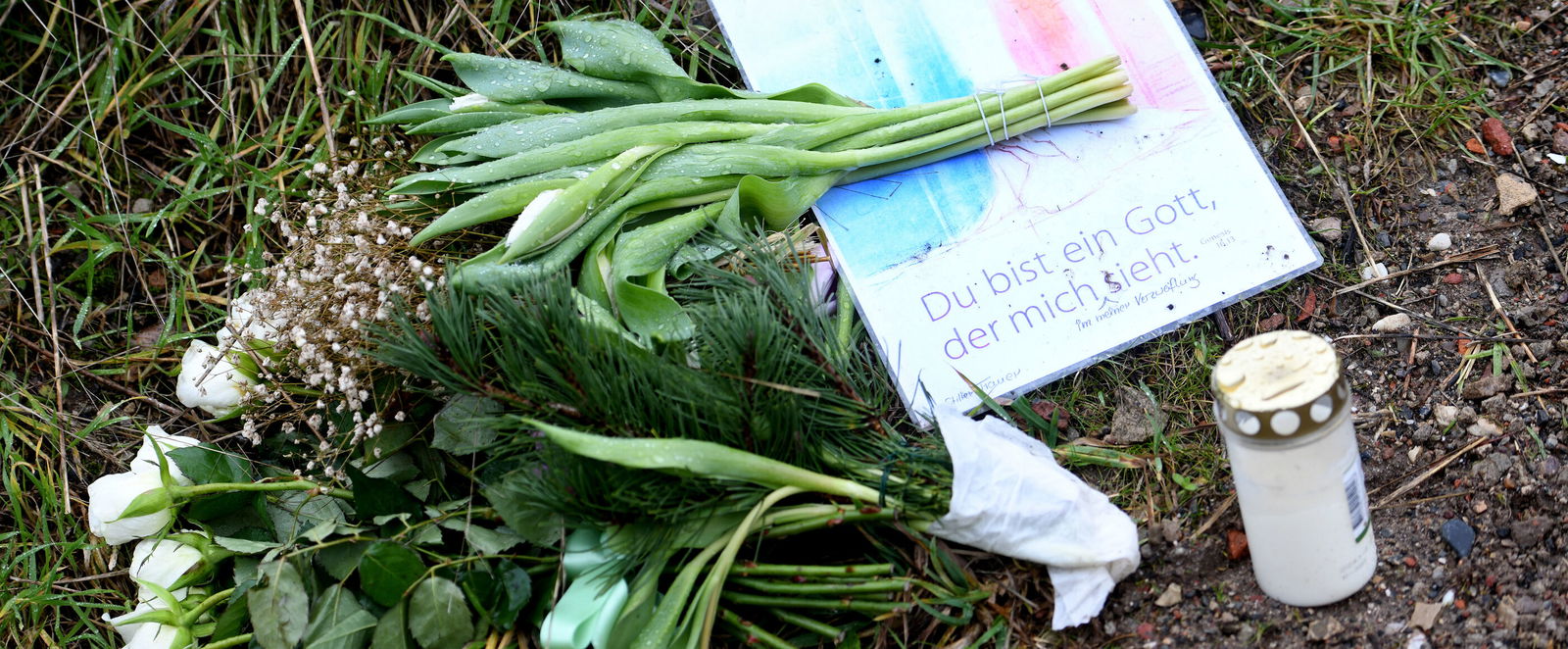 Blumen, eine Kerze und ein Buch auf dem Brachgelände, auf dem der Leichnam des getöteten Schülers gefunden wurde. Foto: epd-bild/Nancy Heusel