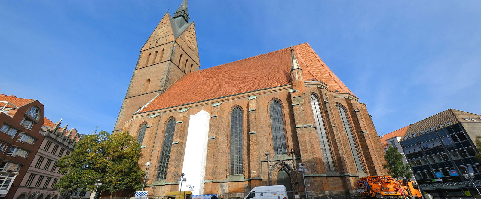 Eine große Kirche unter blauem Himmel, bei der ein Fenster abgeklebt ist.