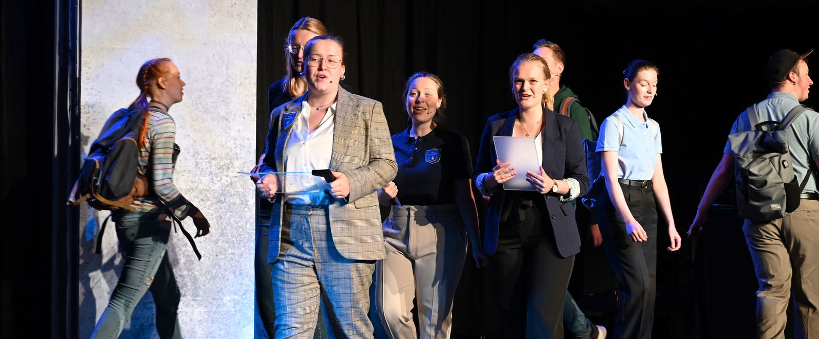 Mehrere junge Menschen gehen eine Musical-Bühne in einer Kirche entlang.