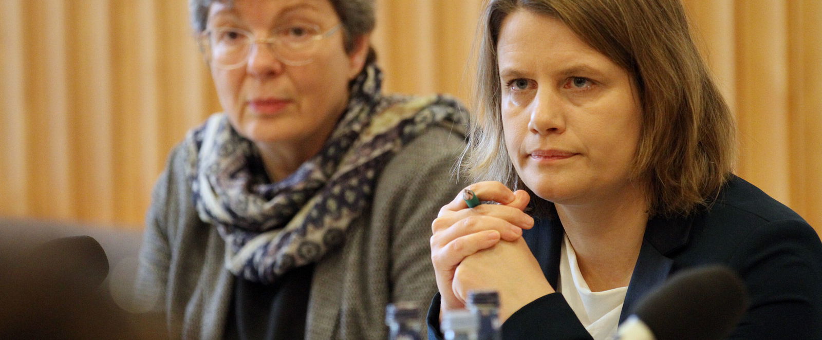 Eine ältere und eine jüngere Frau hören konzentriert zu.