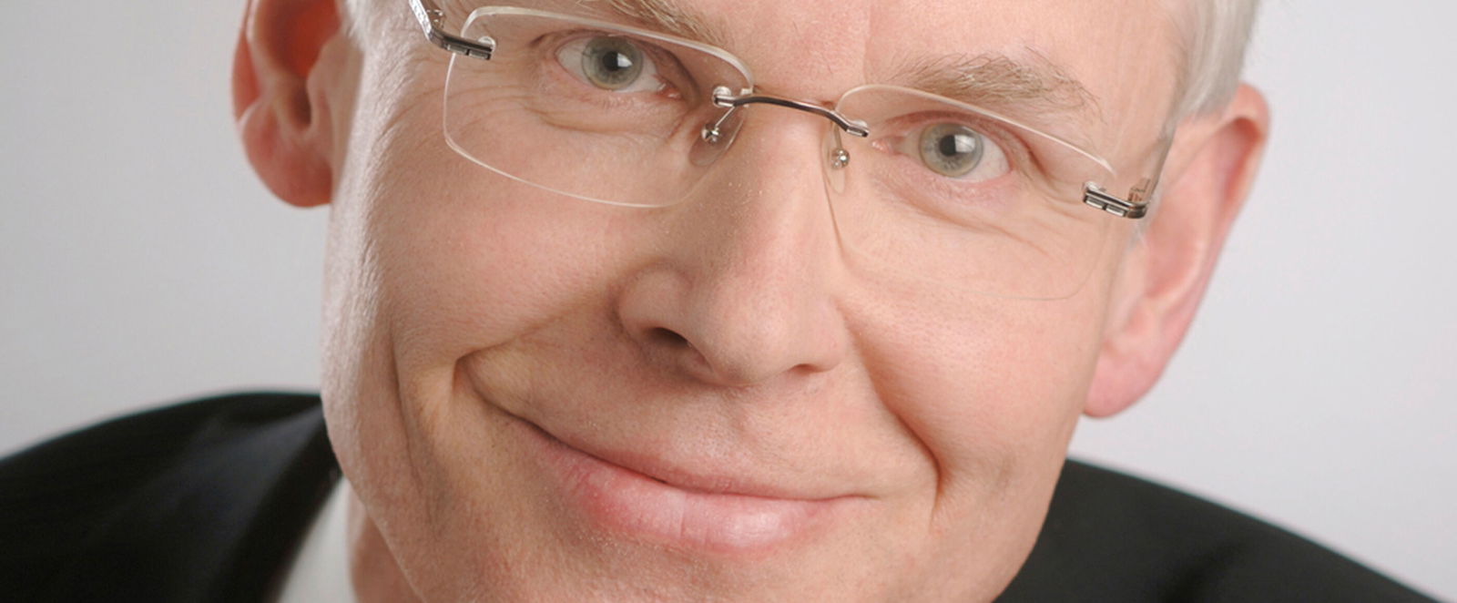 Ein älterer Mann mit grauen Haaren und Brille im Portrait