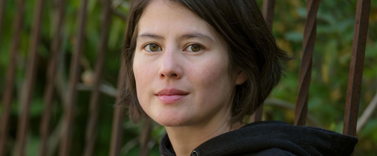 Eine junge Frau vor grünem Hintergrund.