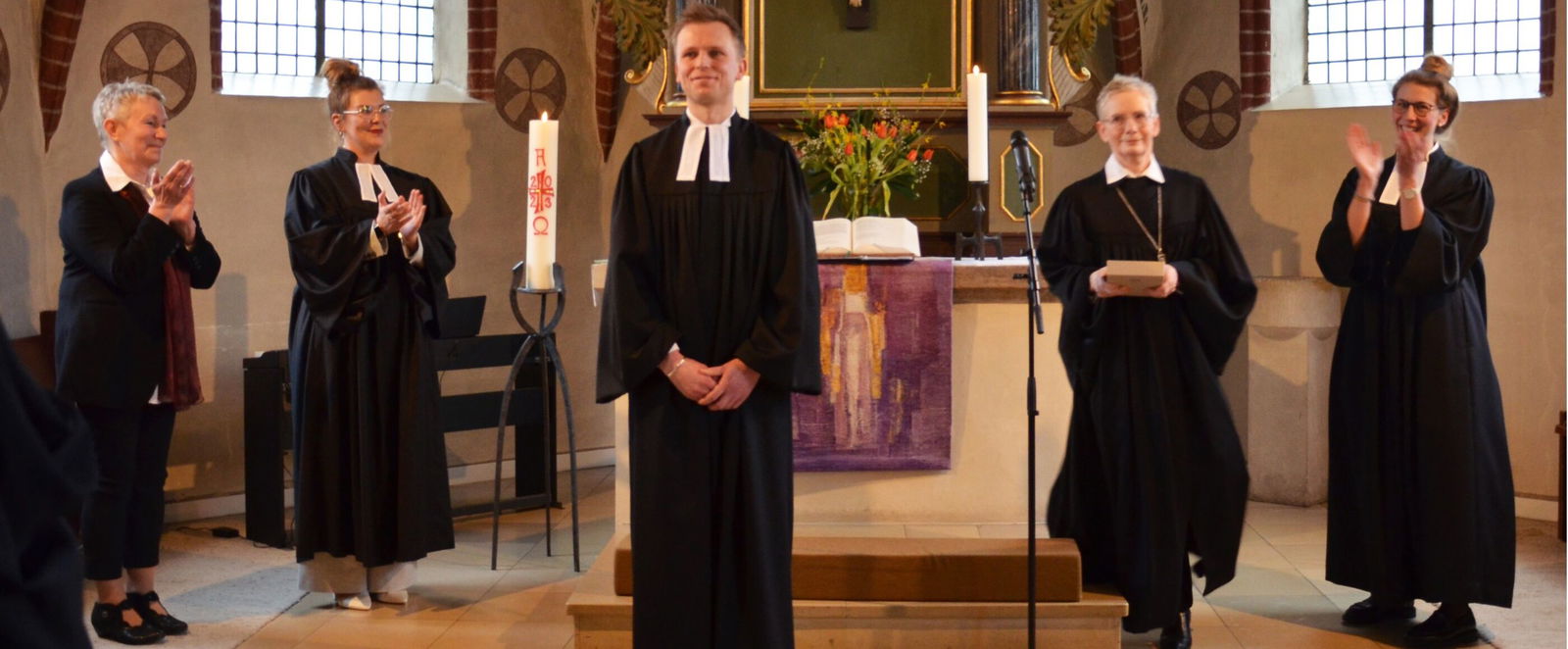 eine Gruppe von Menschen in schwarzen Talaren in einer Kirche.
