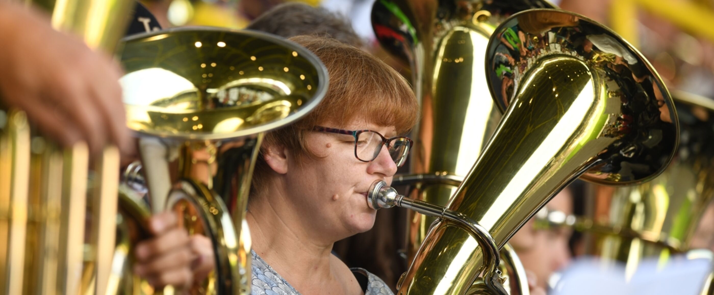 Eine als Frau lesbare Person spielt in einem Posaunenchor