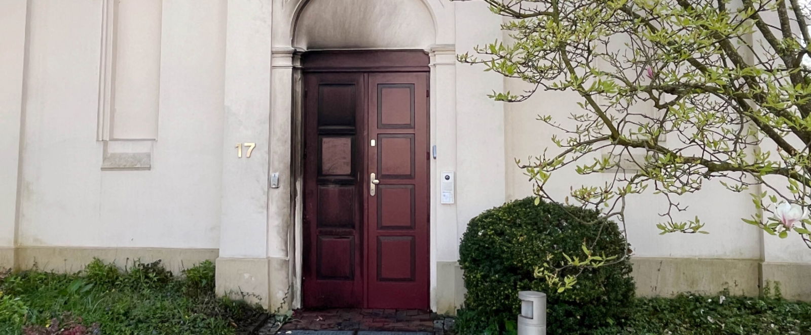 eine Tuer einer Synagoge. Sie ist von Brandspuren gezeichnet.