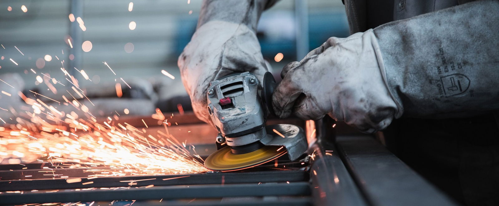 Eine Person erledigt Schweißarbeiten, es sprühen Funken.