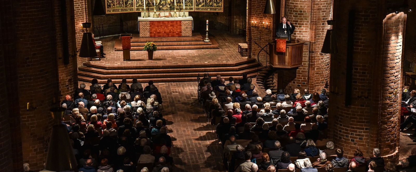 Eine Gottesdienst-Gemeinde hört einer Predigt zu.
