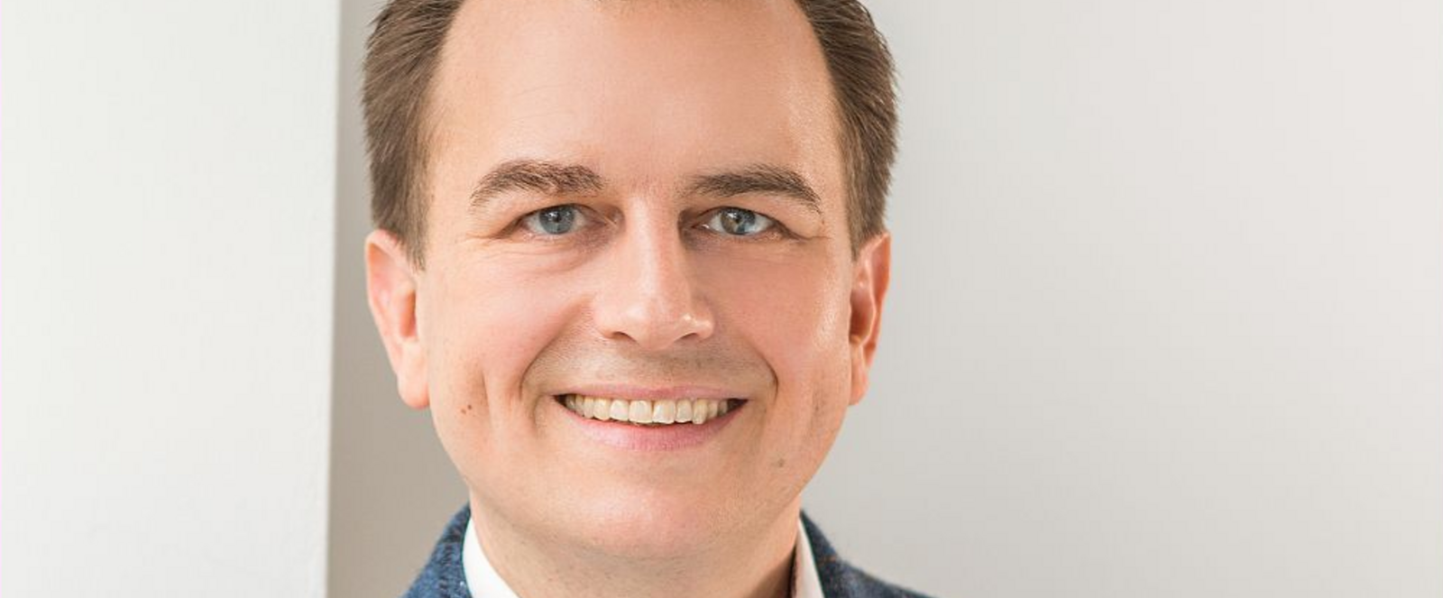 Eine männlich gelesene Person mit dunklen kurzen Haaren