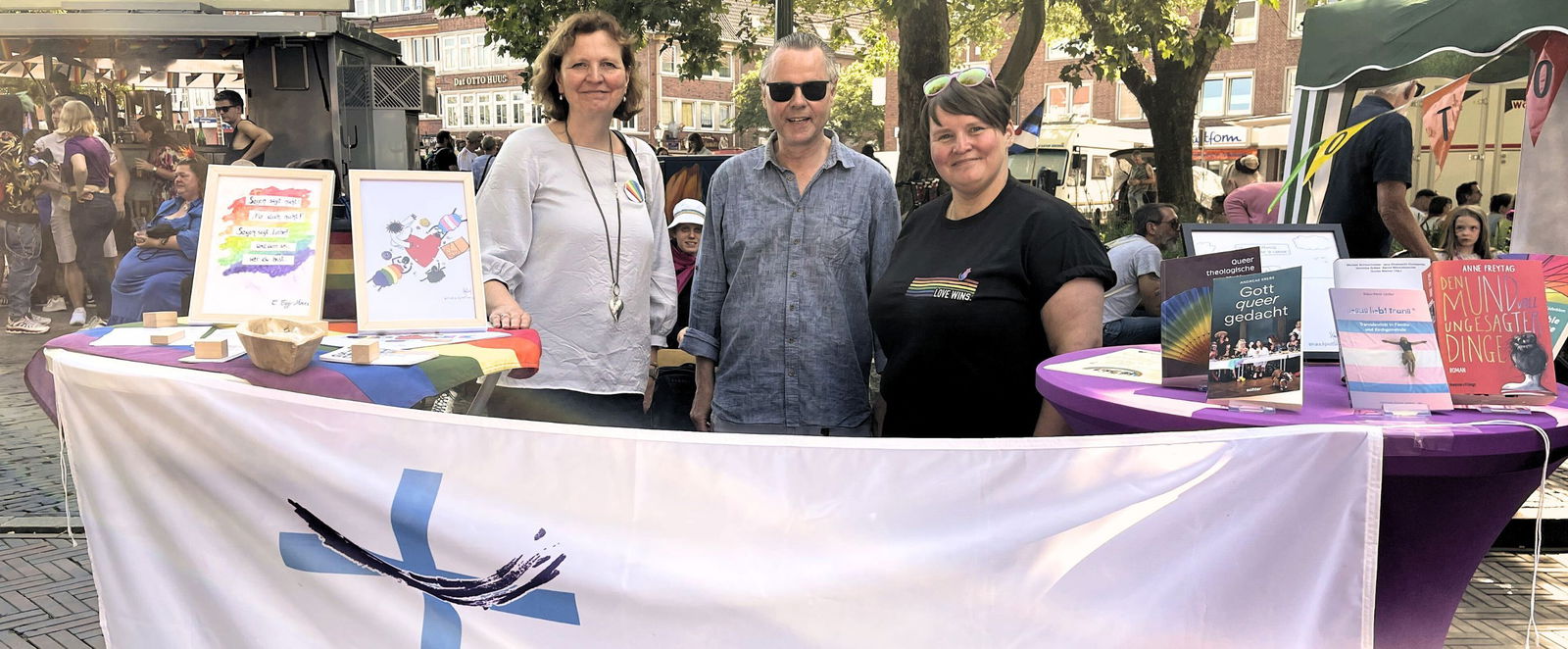 Drei Menschen stehen hinter einem Stand