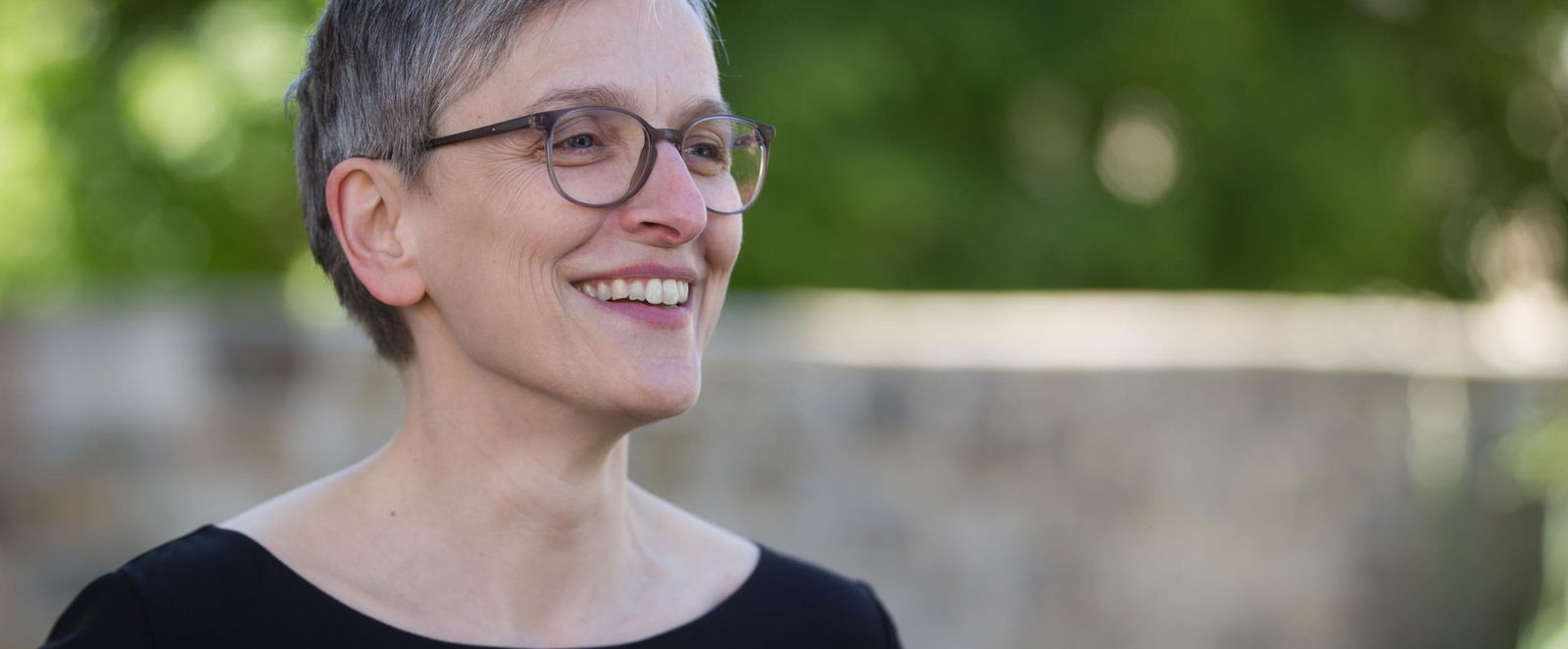 eine Frau lächelt und schaut zur Seite