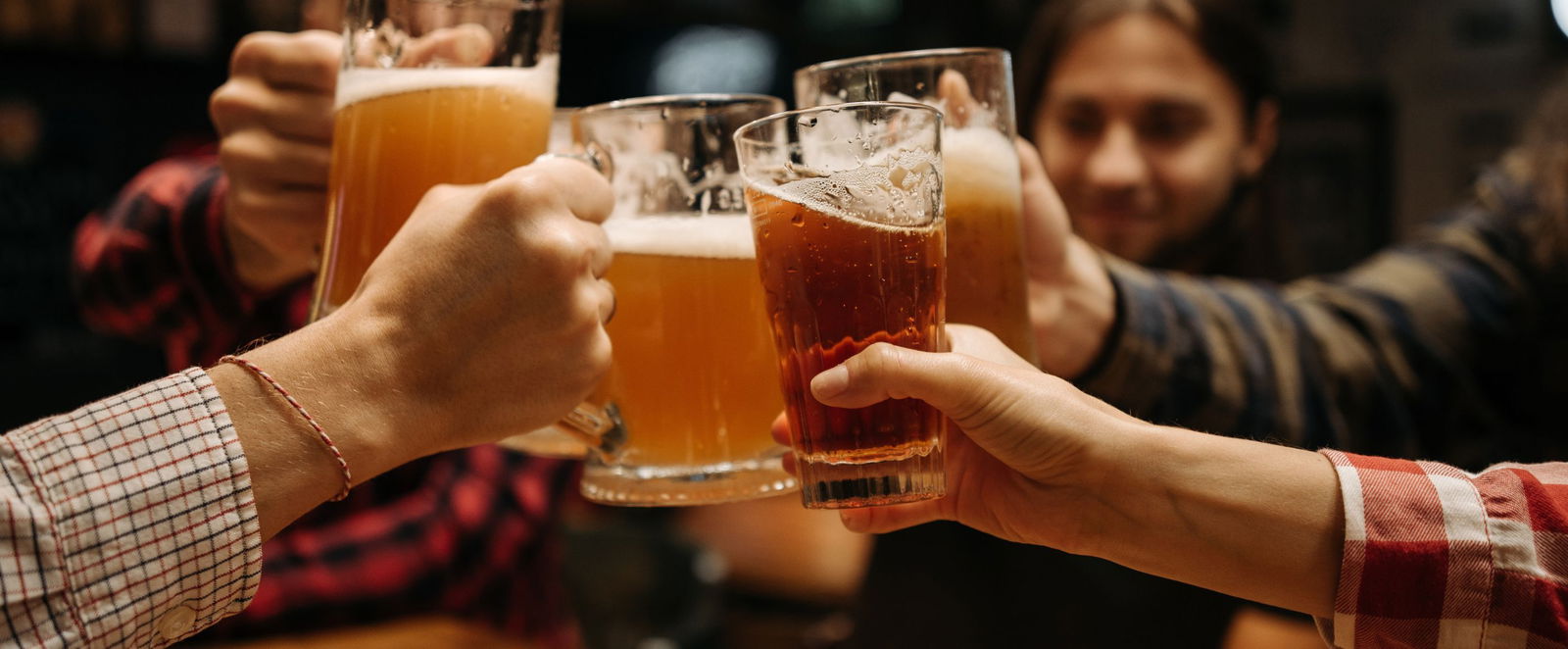 Menschen stoßen mit Getränken miteinander an.