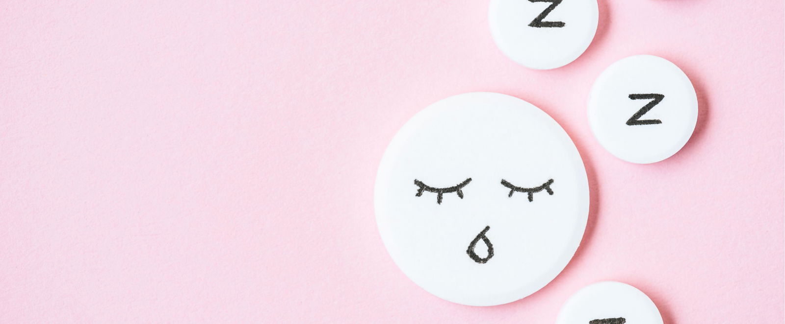 ein Schlaf-Smiley auf rosa Hintergrund.