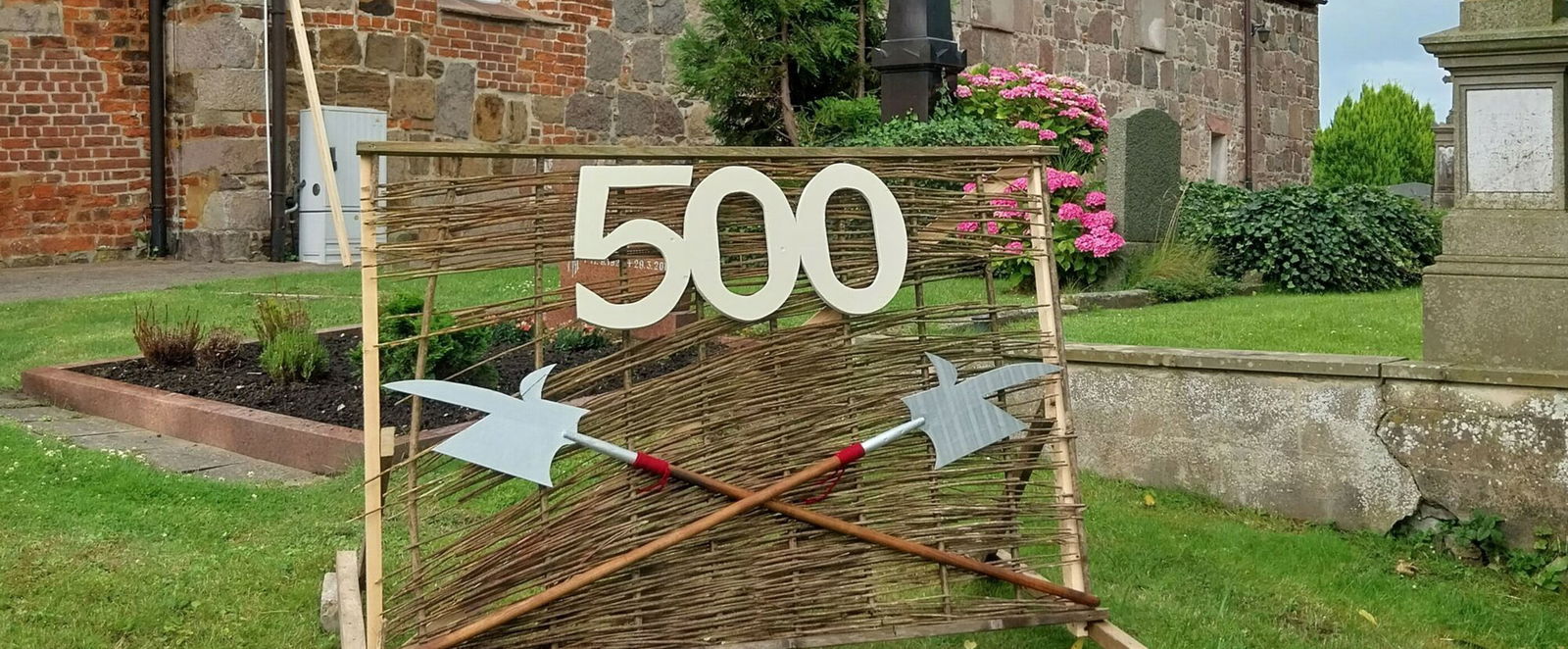 Vor einer Kirche steht eine Installation mit einer 500.