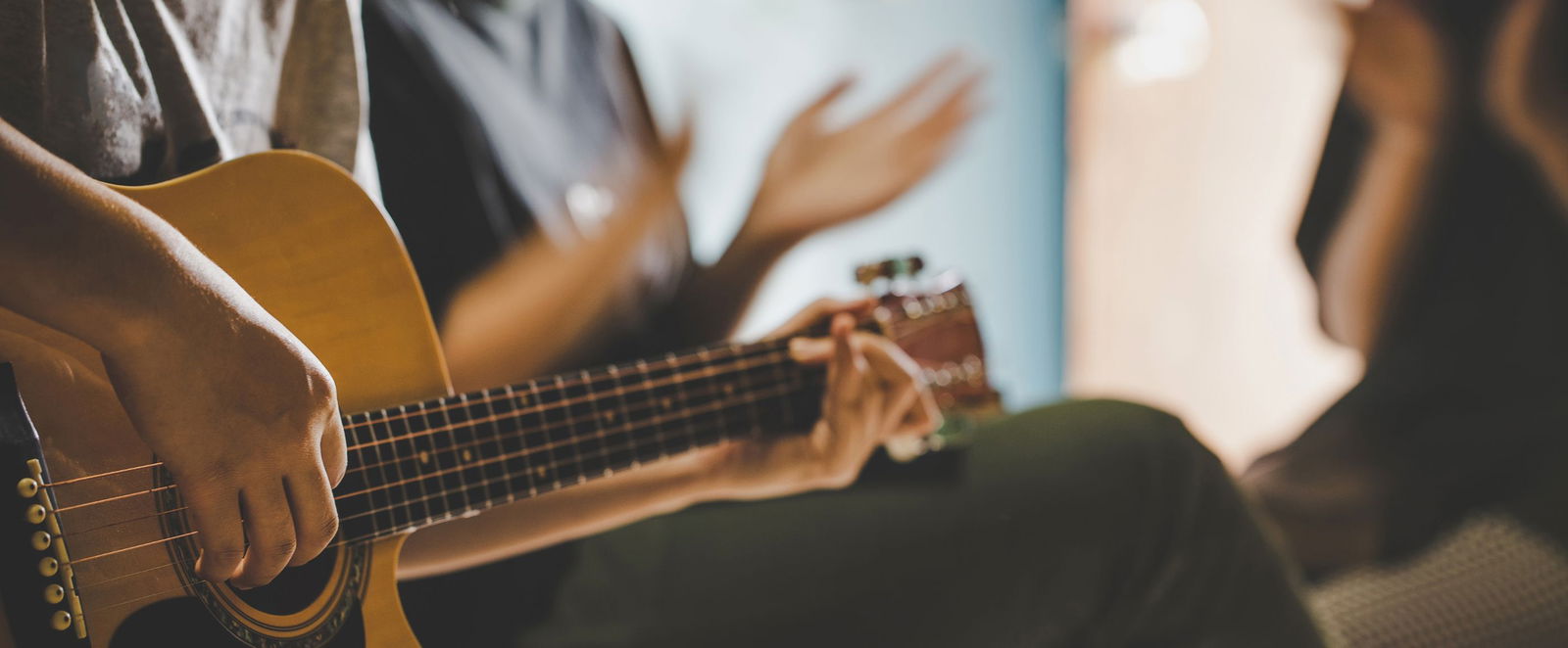Eine Gruppe Menschen spielt Gitarre und gestikuliert.