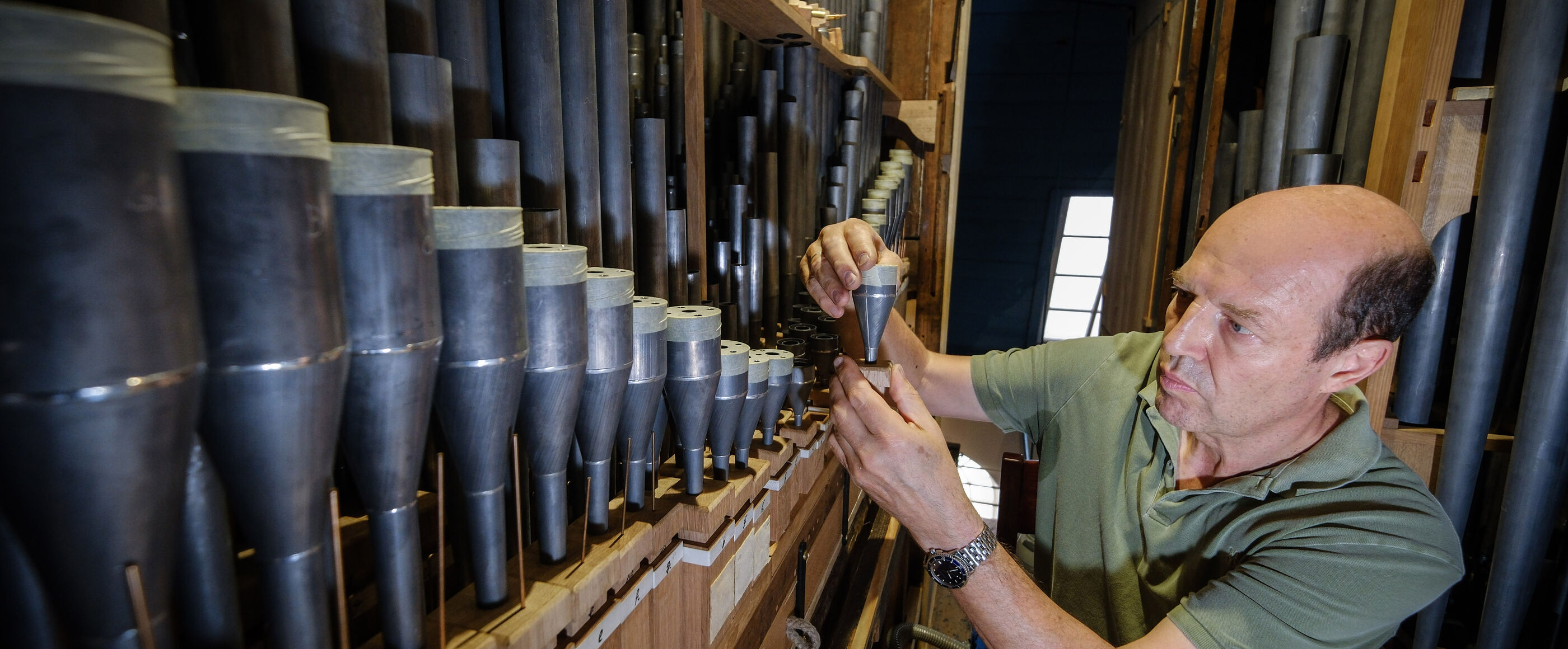 Ein Orgelbauer beim Intonieren einer Orgel
