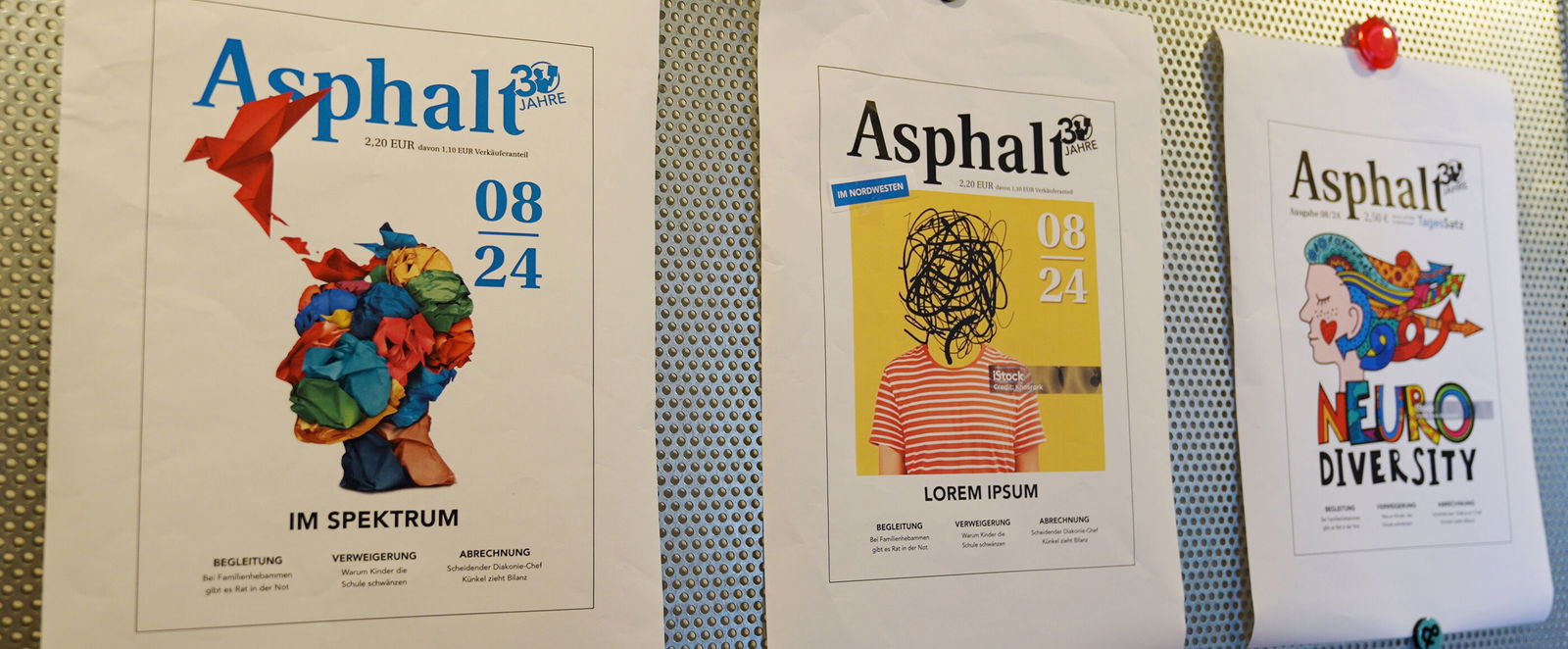 Cover des Straßenmagazins Asphalt pinnen an einer Wand.
