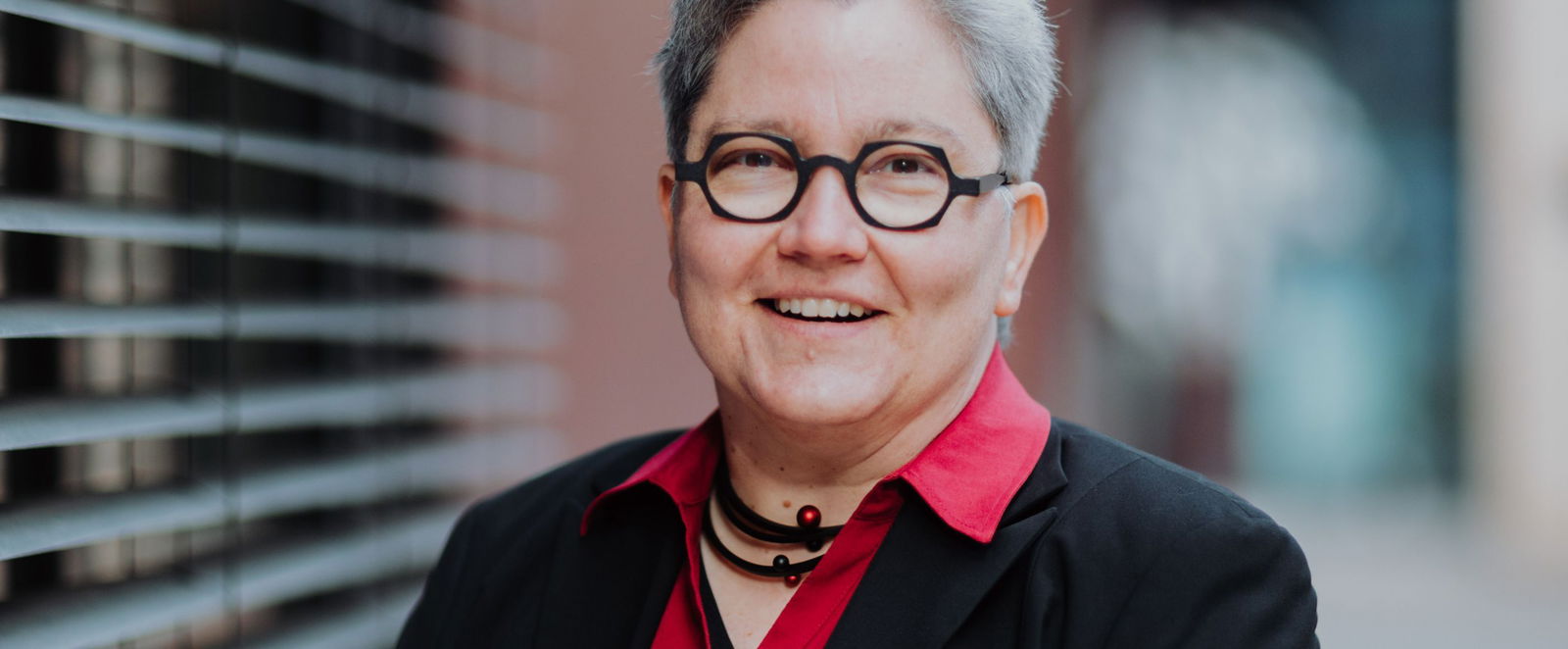 Eine Frau lächelt freundlich in die Kamera.