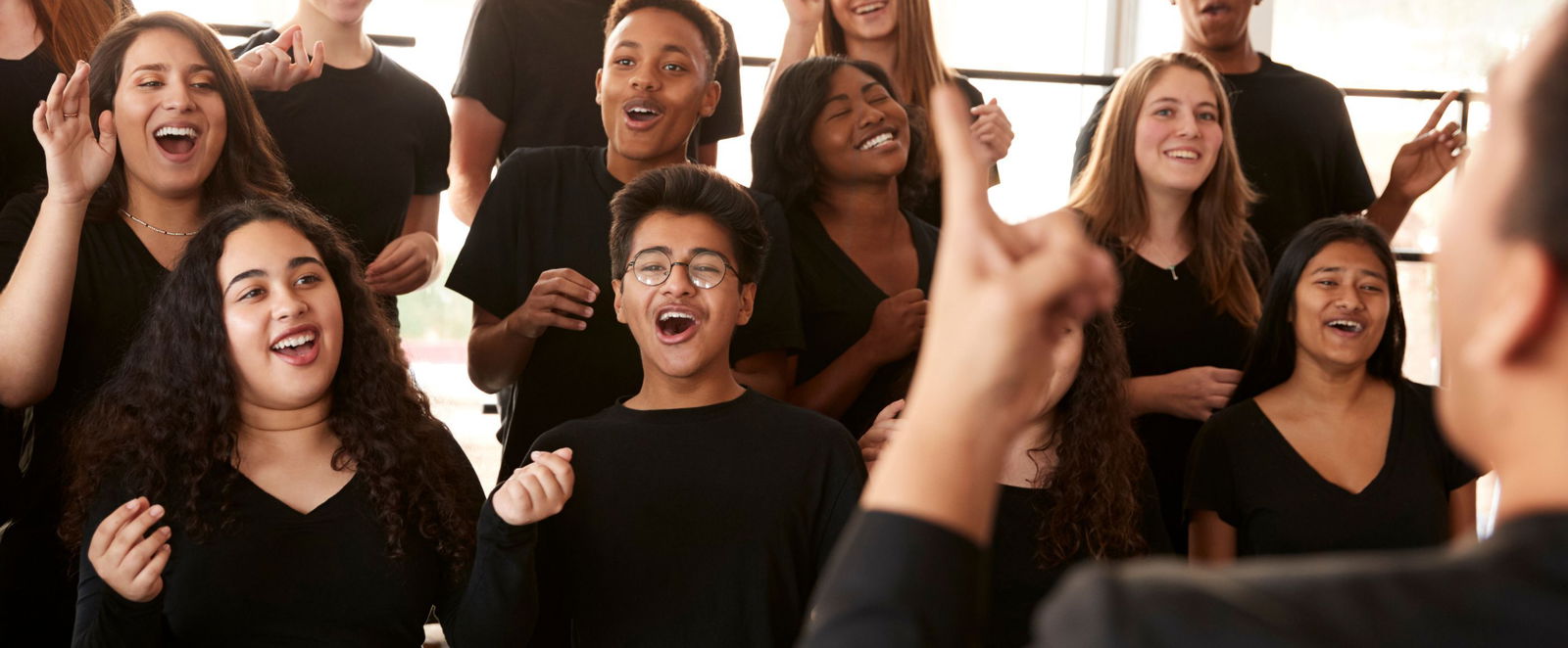 Menschen in schwarzer Kleidung, die fröhlich singen.
