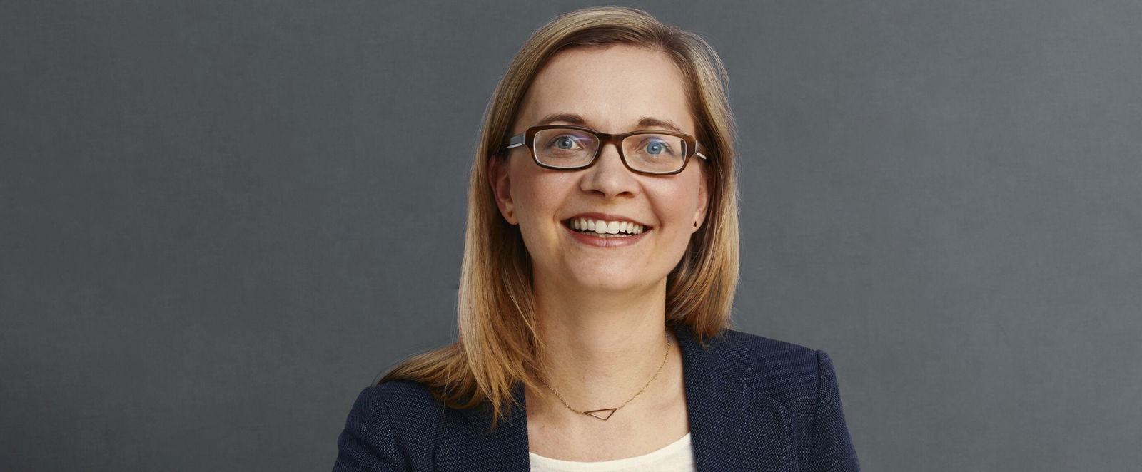 Eine Frau laechelt in die Kamera