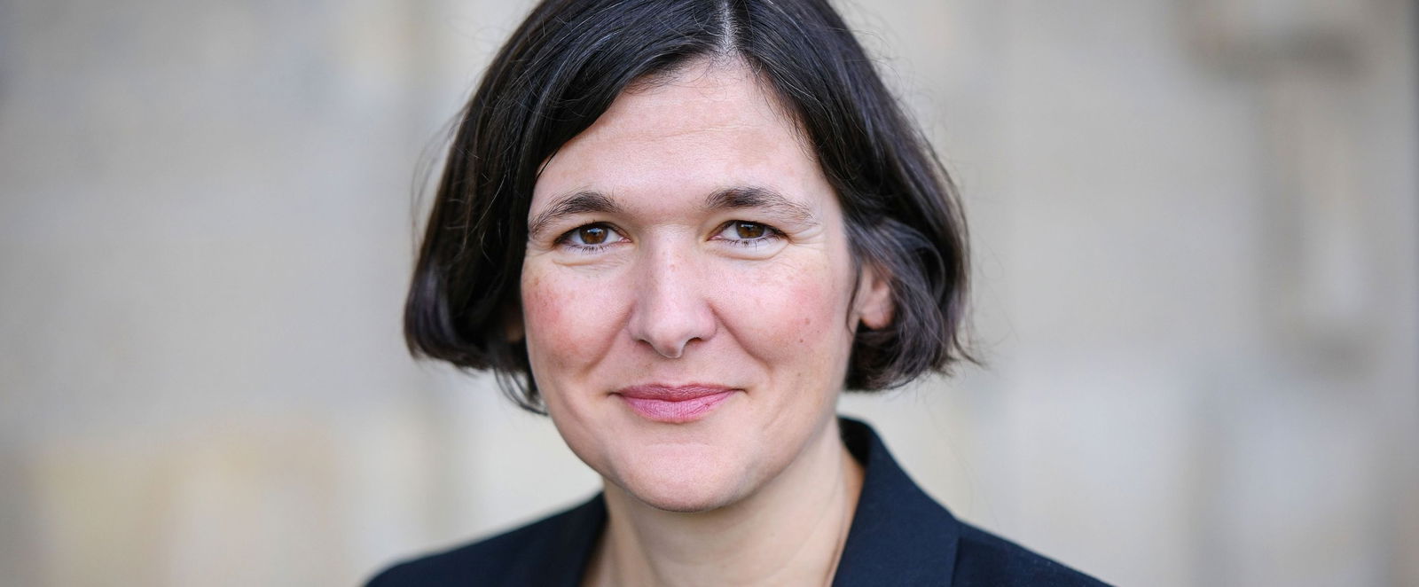 Eine weiblich gelesene Person mit kurzen schwarzen Haaren.