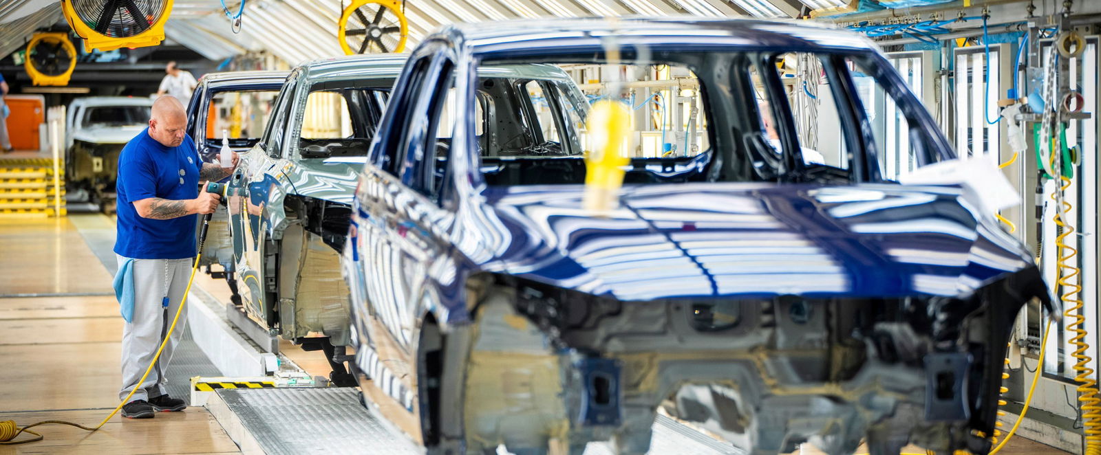 Eine männlich gelesen Person schraubt Autoteile.