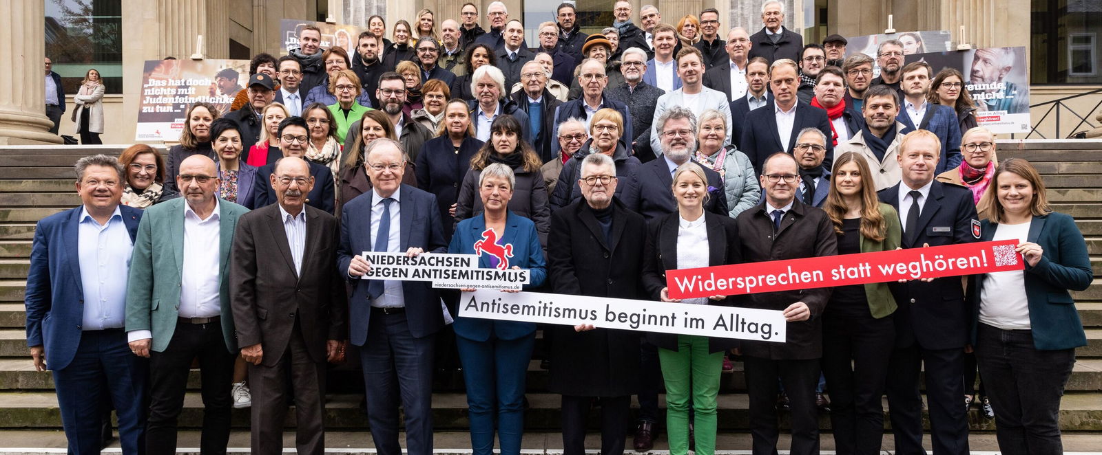Viele Menschen stehen auf einer Treppe vor dem niedersächsischen Landtag und halten Banner auf denen "Niedersachsen gegen Antisemitismus" steht.