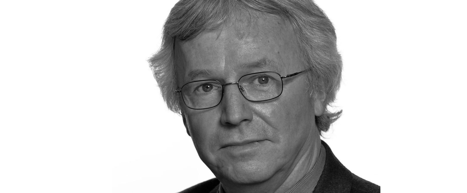 Eine männlich zu lesende Person mit Brille.