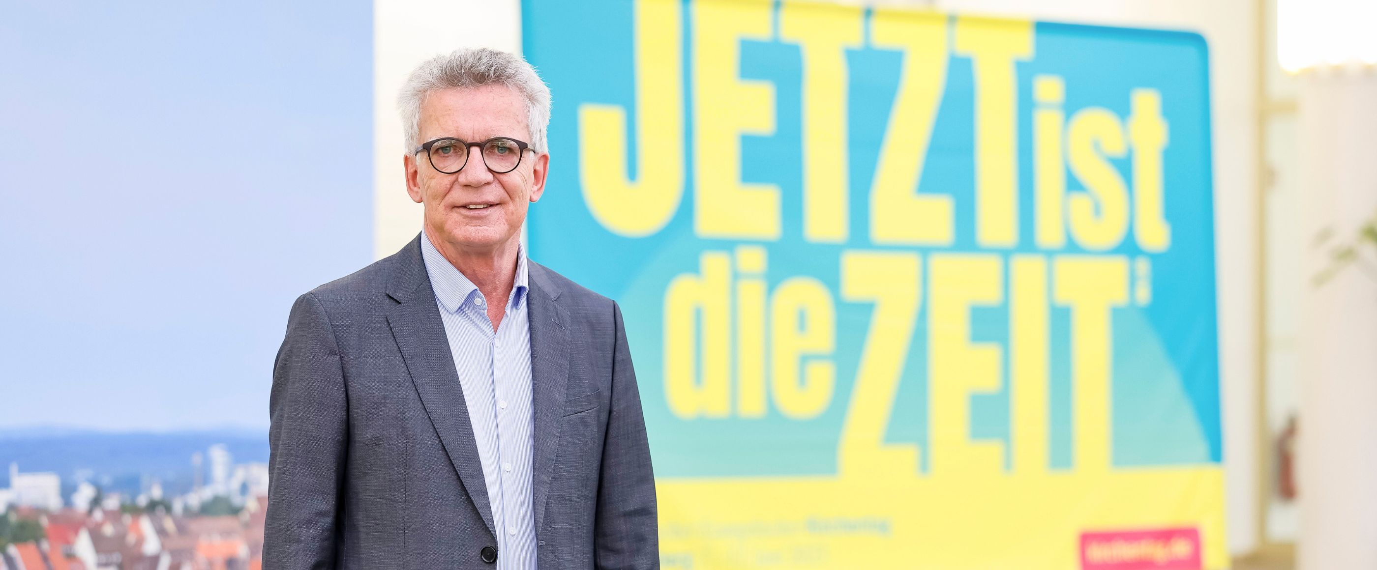 Ein Mann steht vor einem Schild.