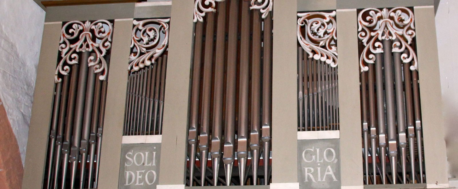 Orgelpfeifen, darunter steht Soli Deo Gloria